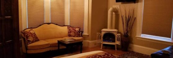 Bette Davis room with corner fireplace, sofa and burgundy and gold accents