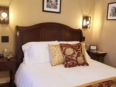 bedroom decorated with burgundy accents and white bedspread
